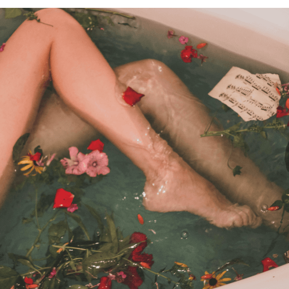 Pernas em uma banheira com flores